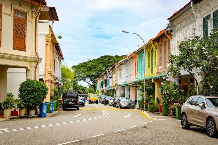 Colourful shophouses line a tree-lined street